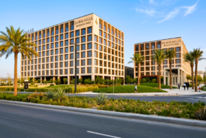 Engineered wood composite louvres and vertical fins on commercial mixed-use tower podium in Dubai — biophilic façade design UAE